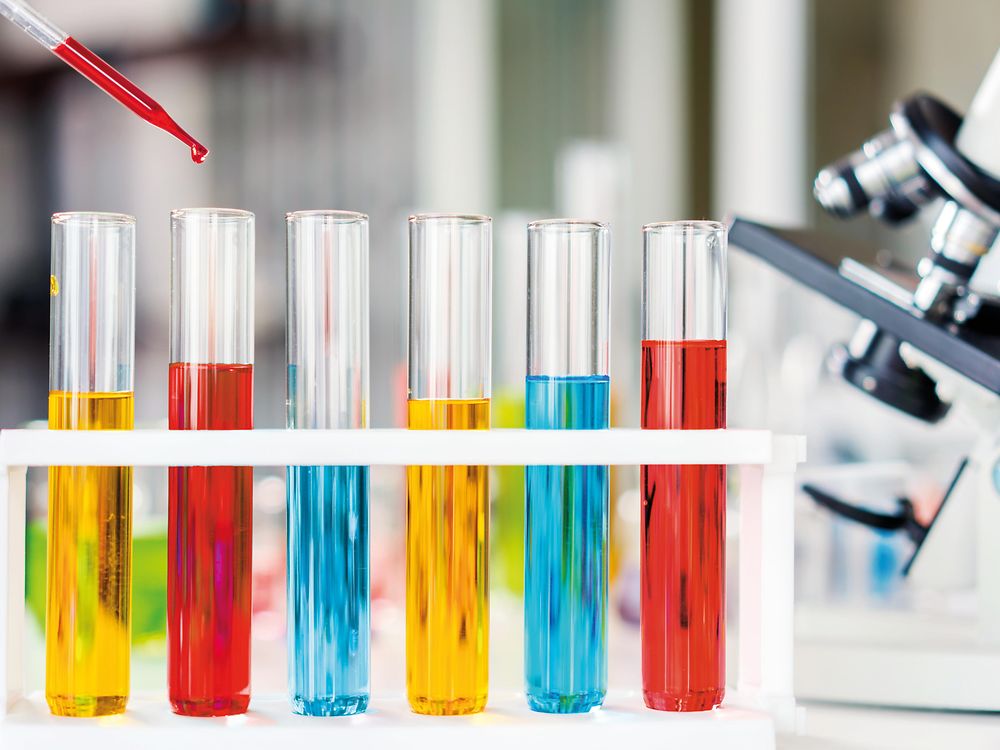 Test tubes are filled with red, yellow and blue liquids representing chemicals for evaluation and registration in the REACH context.